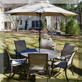 L01. Round powdered aluminum patio table and 6 chairs. Table measures 28”h x 55”w Chairs: 39”h 